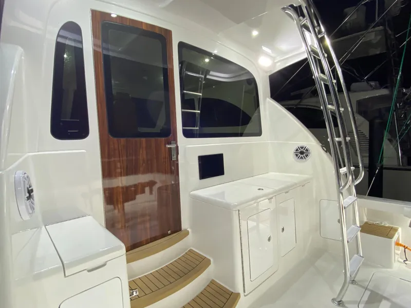 Slide: The Image of Henriques 42 EXHTB 2025 yacht cockpit with ladder, wooden door, and storage cabinets. - 10