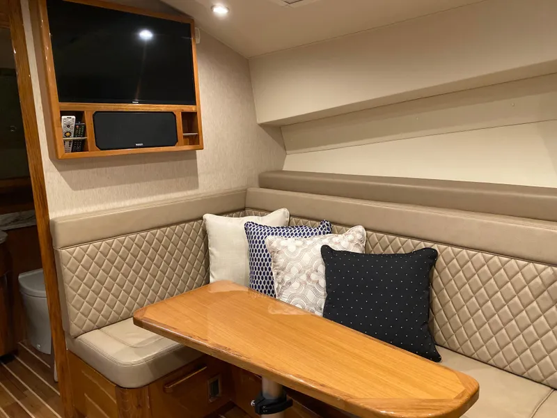 Slide: The Image of Henriques 42 EXHTB 2025 interior with cushioned seating, wooden table, and mounted TV. - 24