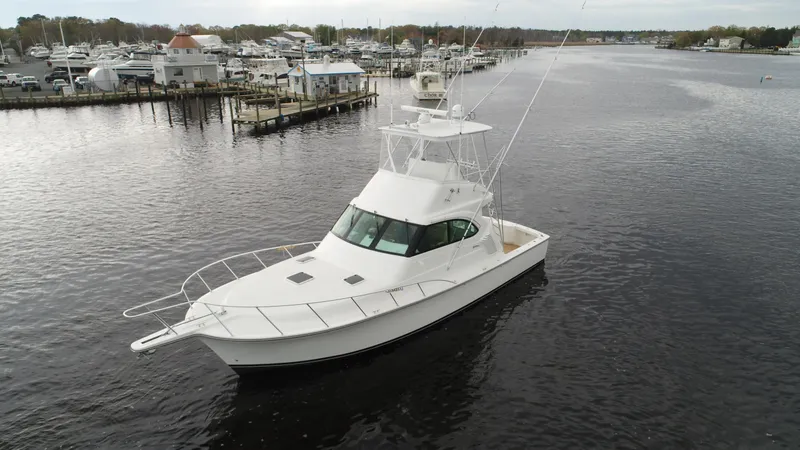 Slide: The Image of 2025 Henriques 42 EXHTB yacht cruising on a calm river near a marina. - 3