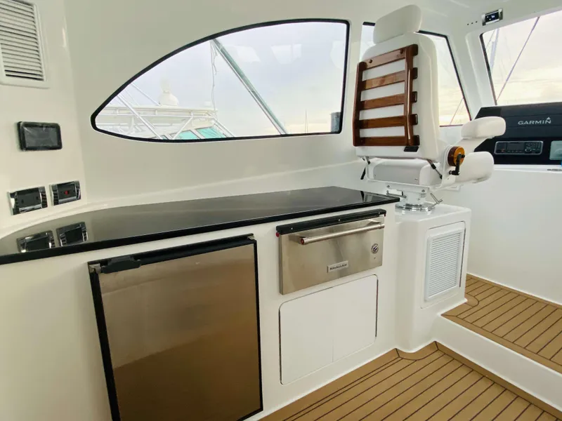 Slide: The Image of Interior of 2025 Henriques 42 EXHTB yacht with captain's chair and kitchenette. - 20