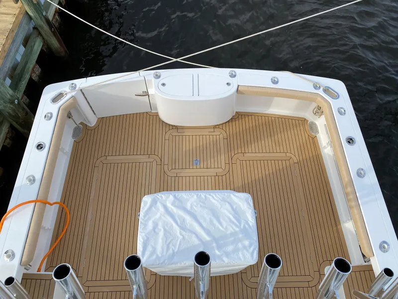 Slide: The Image of Henriques 42 EXHTB 2025 boat deck with teak flooring and fishing rod holders. - 8