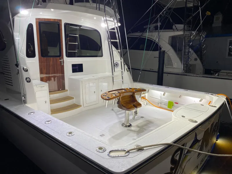 Slide: The Image of 2025 Henriques 42 EXHTB boat with illuminated deck and fishing chair at night. - 9