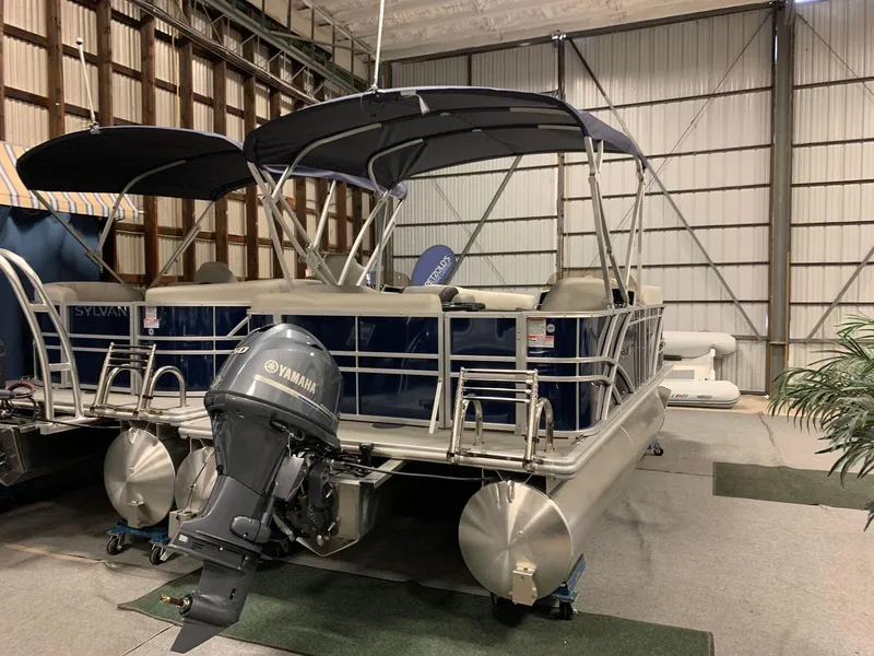 Slide: The Image of Sylvan Mirage 818 Cruise 2026 pontoon boat in warehouse. - 2