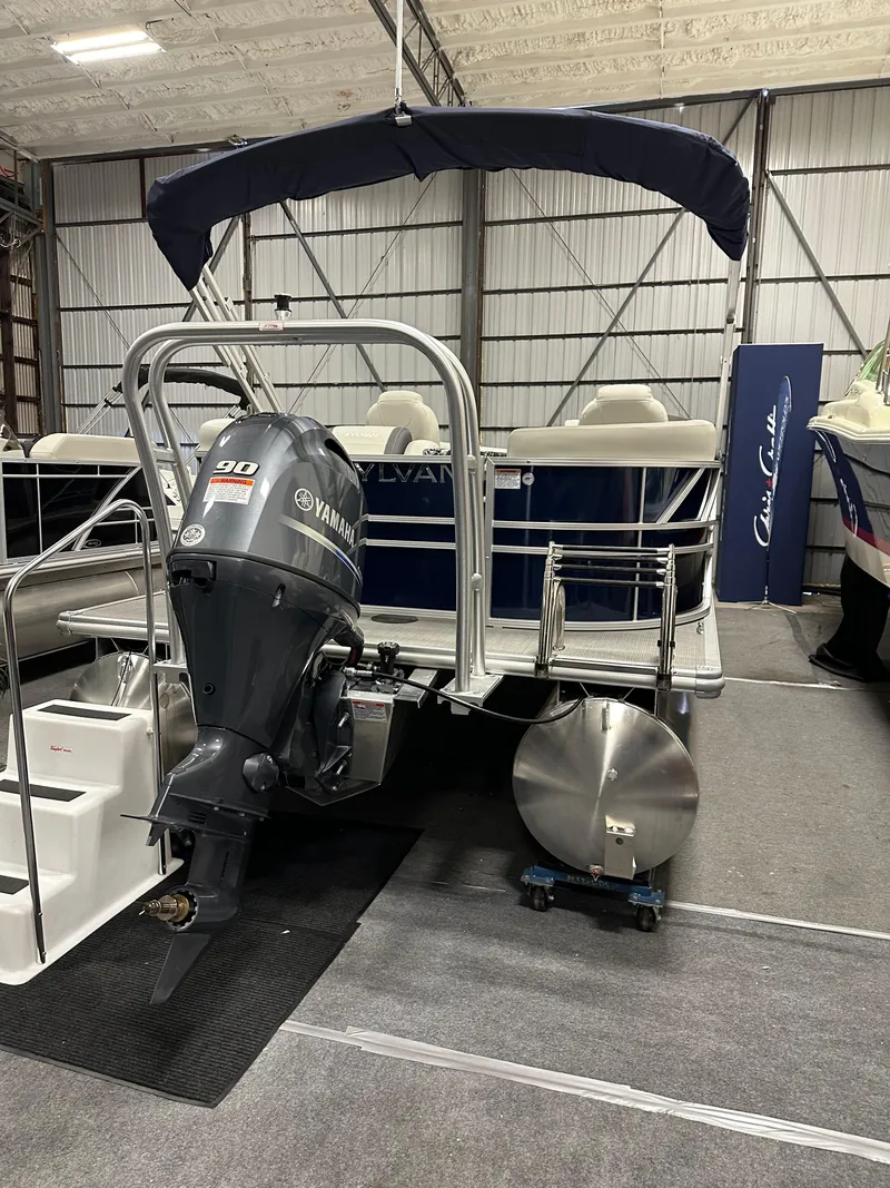 Slide: The Image of 2026 Sylvan Mirage 8520 LZ pontoon boat with Yamaha outboard motor in storage facility. - 4