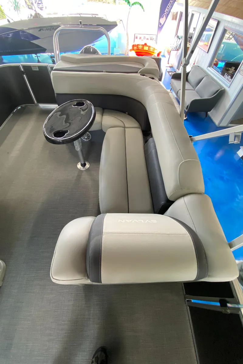 Slide: The Image of 2022 Sylvan Mirage 8522 Cruise pontoon boat interior with plush seating and table. - 9