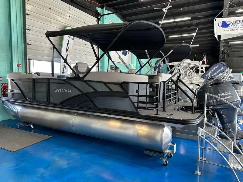 The Image of 2025 Sylvan Mirage L-1 LZ pontoon boat displayed indoors with Yamaha engine. - 0
