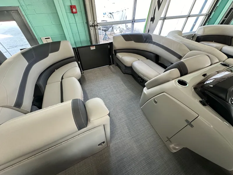 Slide: The Image of 2025 Sylvan Mirage L-1 LZ interior at Petzold's Marine Center, featuring comfortable seating and privacy curtain. - 11