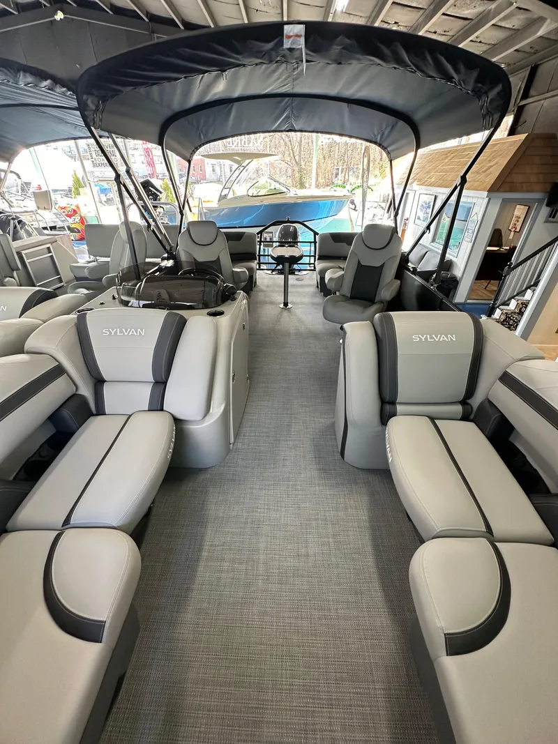 Slide: The Image of 2025 Sylvan Mirage L-1 LZ pontoon boat interior with plush seating and canopy. - 13