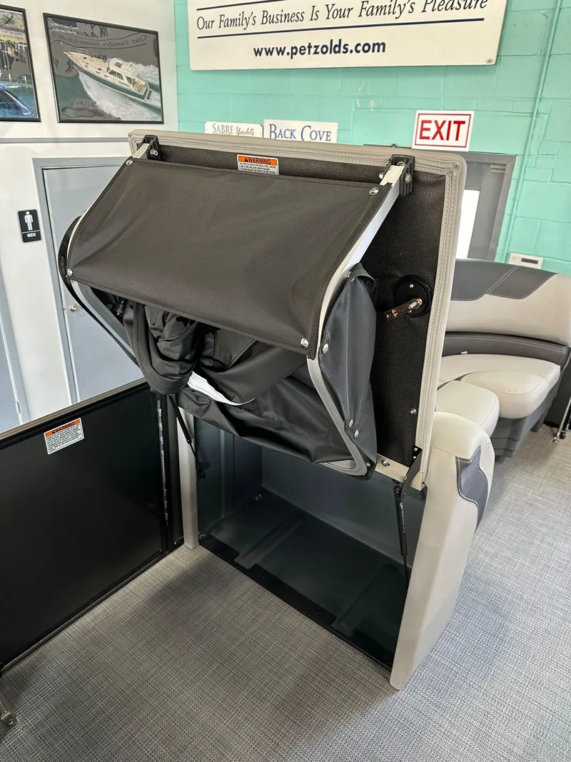 Slide: The Image of 2025 Sylvan Mirage L-1 LZ boat interior with gray seating and storage compartment. - 9