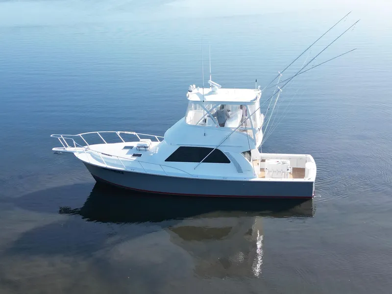 The Image of 2025 Henriques 42 Flybridge yacht on calm water, showcasing sleek design and spacious deck. - 0