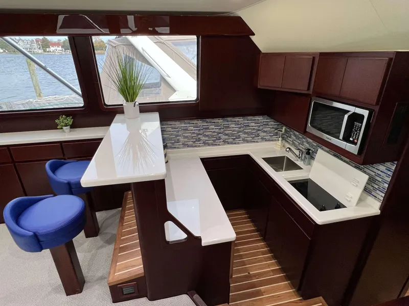 Slide: The Image of Interior of 2025 Henriques 42 Flybridge yacht with modern kitchen and seating area. - 12