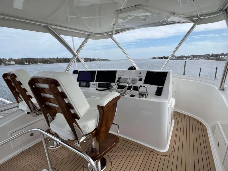 Slide: The Image of 2025 Henriques 42 Flybridge helm with dual seats, overlooking serene waters. - 35