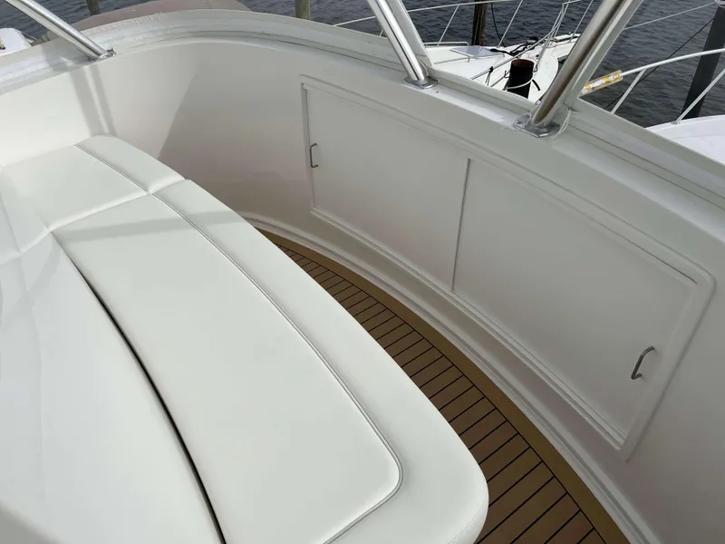 Slide: The Image of 2025 Henriques 42 Flybridge interior with white seating and wooden flooring. - 37