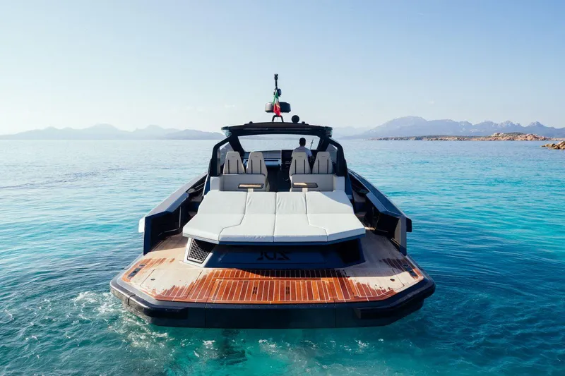 Slide: The Image of Luxury Maori 54 yacht, 2020 model, anchored in clear blue waters with scenic mountain backdrop. - 11