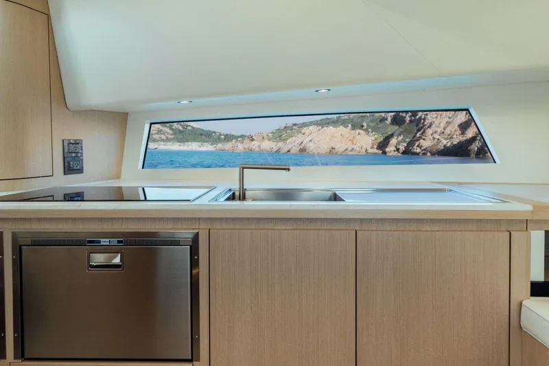 Slide: The Image of Modern kitchen interior of Maori 54 yacht with ocean view, stainless steel appliances, and wooden cabinetry. - 23