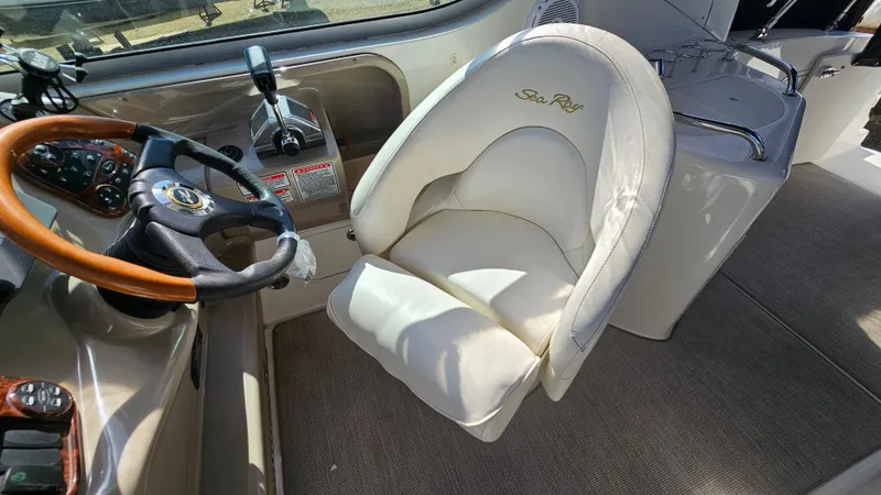 Slide: The Image of 2003 Sea Ray 280 Sundancer helm with steering wheel and captain's chair. - 11