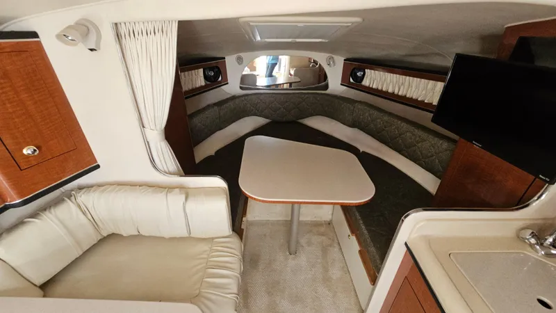 Slide: The Image of Interior of 2003 Sea Ray 280 Sundancer with seating, table, and TV. - 13