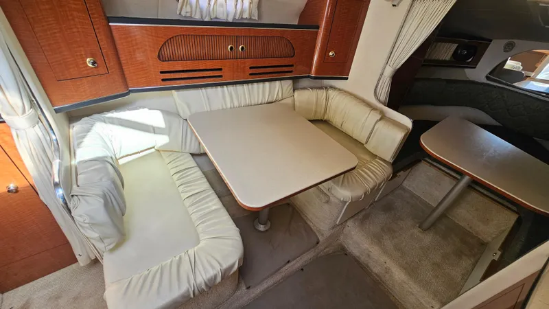 Slide: The Image of 2003 Sea Ray 280 Sundancer cabin interior with dining area and seating. - 18