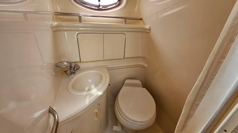 Slide: The Image of 2003 Sea Ray 280 Sundancer bathroom with sink, toilet, and storage cabinets. - 21