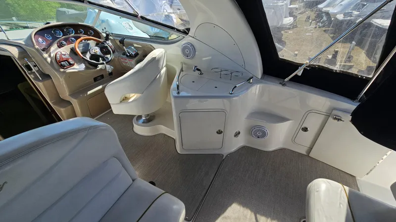 Slide: The Image of 2003 Sea Ray 280 Sundancer cockpit with helm, seating, and control panel. - 8