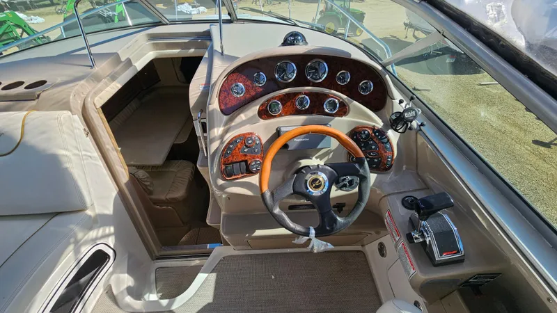 Slide: The Image of 2003 Sea Ray 280 Sundancer boat cockpit with steering wheel and control panel. - 9