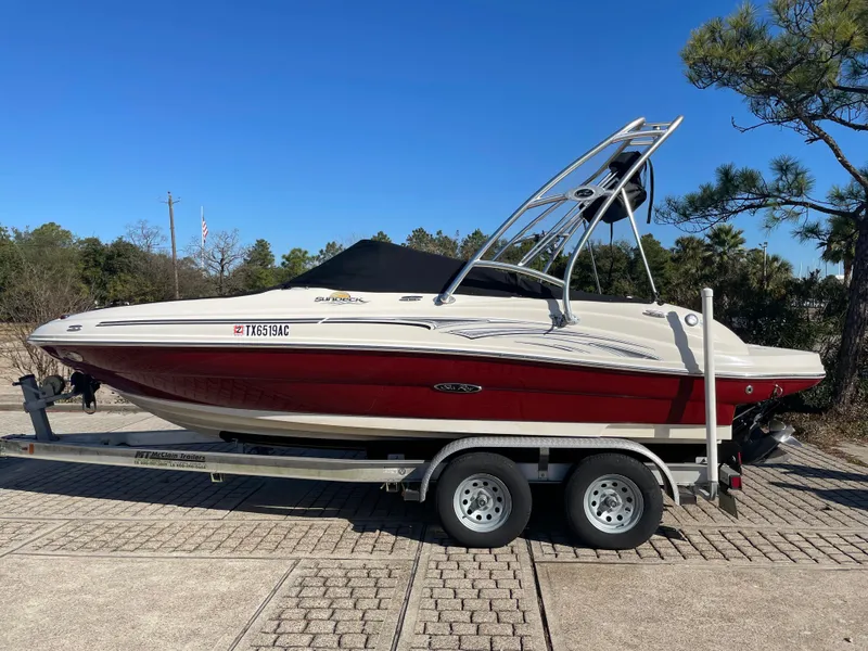 Slide: The Image of 2006 Sea Ray 200 Sundeck boat on trailer, red and white design, parked outdoors. - 3