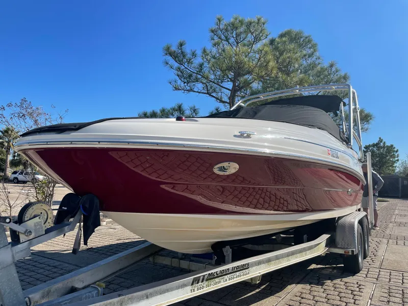 The Image of 2006 Sea Ray 200 Sundeck boat on trailer, red and white design, sunny day. - 0