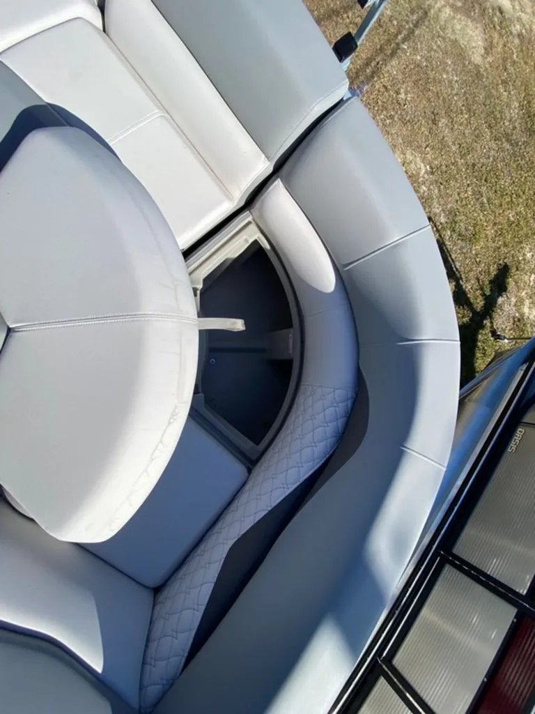 Slide: The Image of 2022 Manitou 23 Encore RF VP boat with open storage compartment under cushioned seats. - 20