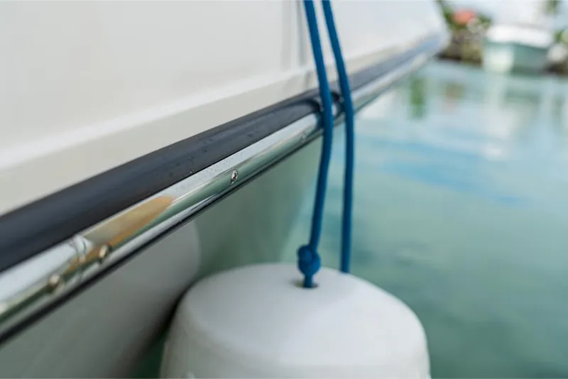 Slide: The Image of Close-up of 2023 Boston Whaler 360 Outrage boat with fender and blue rope. - 13