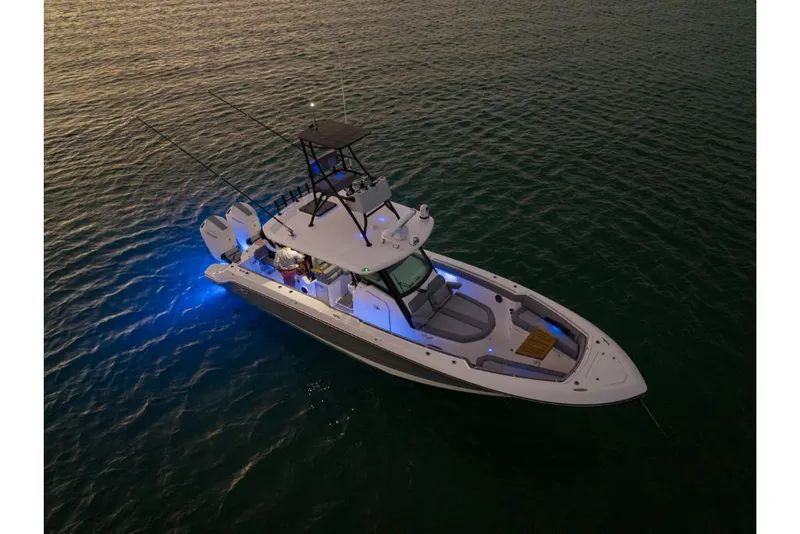 Slide: The Image of 2023 Boston Whaler 360 Outrage boat illuminated on water at dusk. - 38