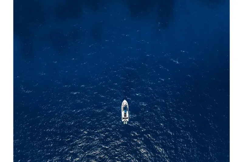 Slide: The Image of Aerial view of a 2023 Boston Whaler 360 Outrage boat on open blue water. - 44