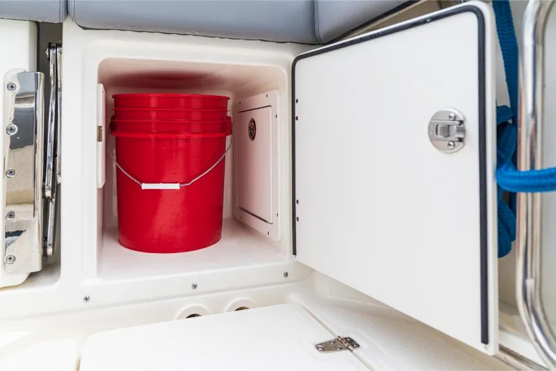 Slide: The Image of Storage compartment with red bucket on 2023 Boston Whaler 360 Outrage boat. - 7
