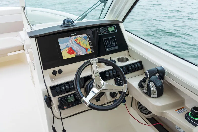 Slide: The Image of 2024 Boston Whaler 280 Vantage helm with navigation display and controls. - 13