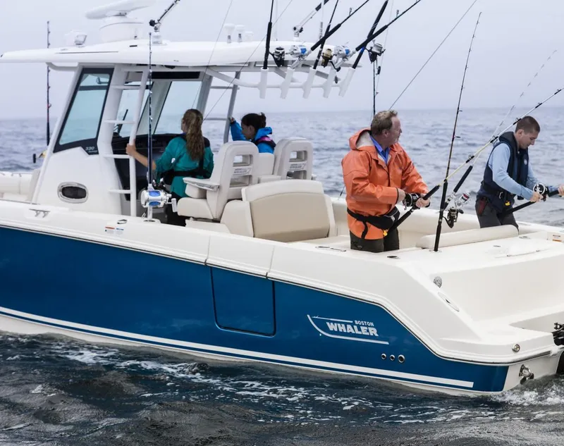 Slide: The Image of 2024 Boston Whaler 330 Outrage boat with people fishing at sea. - 11