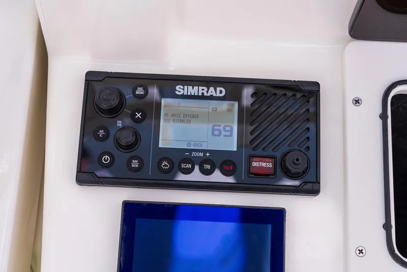 Slide: The Image of Simrad marine radio on 2024 Boston Whaler 330 Outrage dashboard. - 15