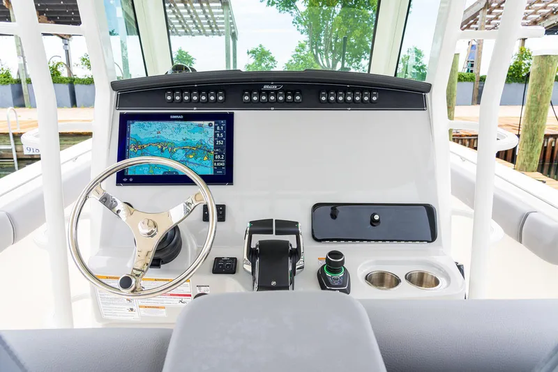 Slide: The Image of 2024 Boston Whaler 330 Outrage helm with steering wheel and navigation display. - 16