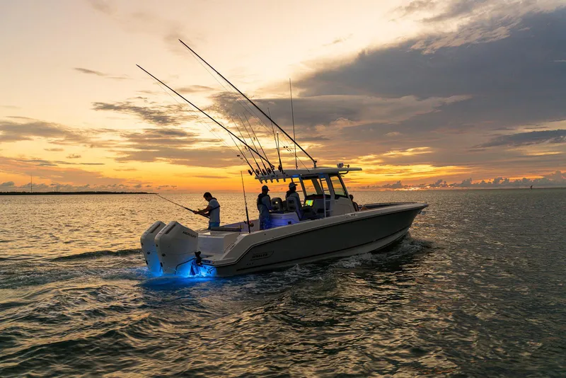 Slide: The Image of 2024 Boston Whaler 330 Outrage boat at sunset, equipped for fishing. - 18