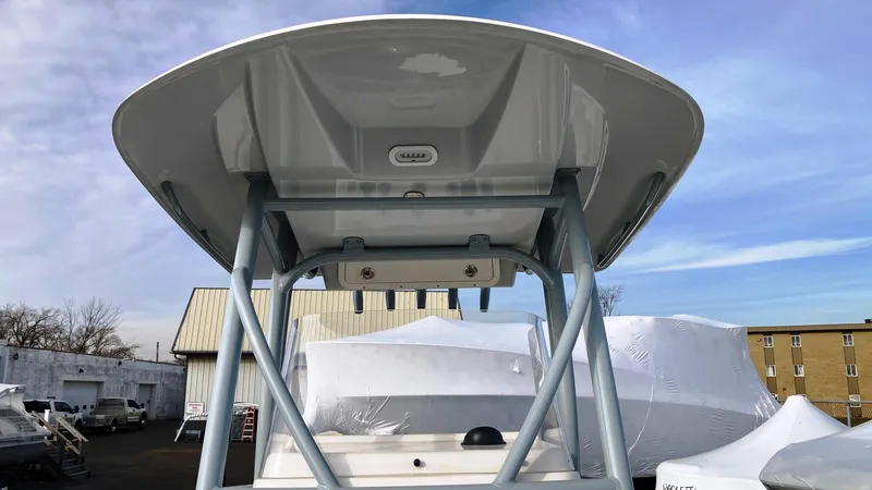 Slide: The Image of 2022 Cobia 220 CC boat with T-top, parked outdoors. - 10