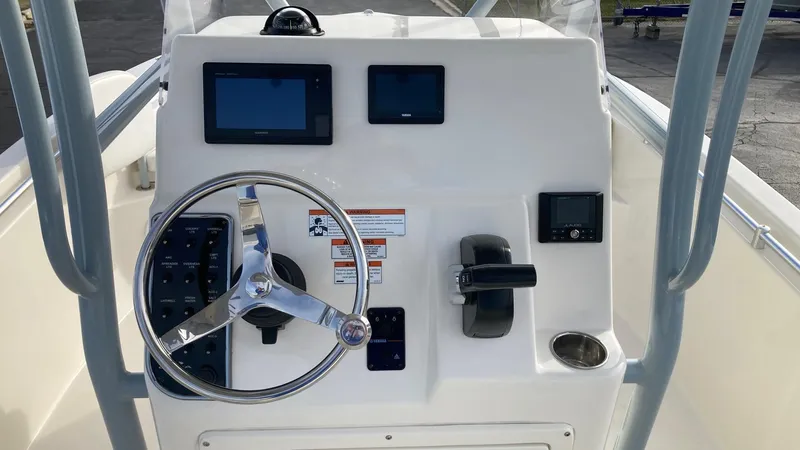 Slide: The Image of 2022 Cobia 220 CC boat console with steering wheel and navigation screens. - 15