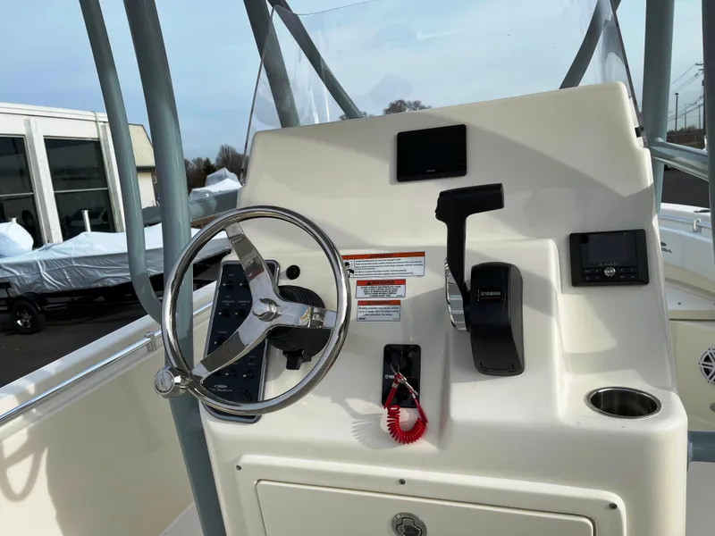 Slide: The Image of 2022 Cobia 220 CC boat console with steering wheel and controls. - 16