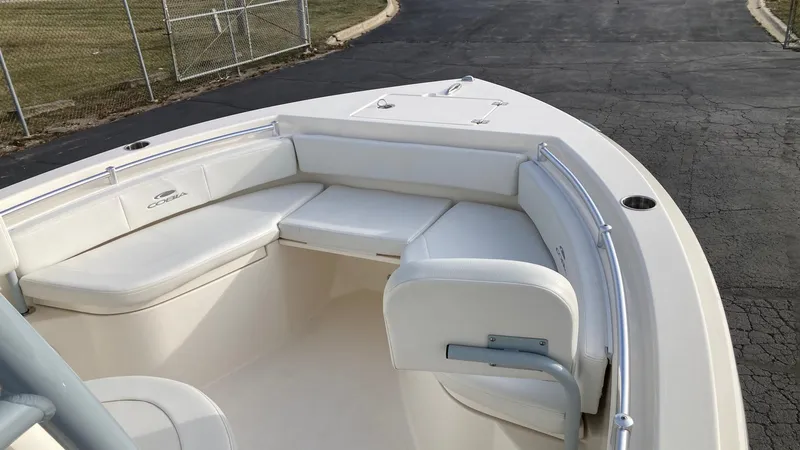 Slide: The Image of 2022 Cobia 220 CC boat with white cushioned seating in the bow area. - 18