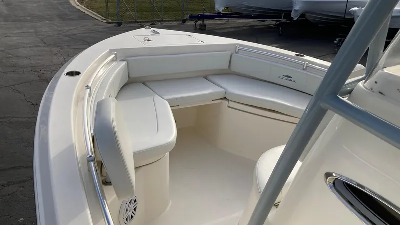 Slide: The Image of 2022 Cobia 220 CC boat with white seating and spacious deck. - 19