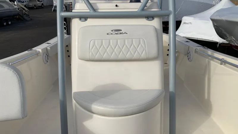Slide: The Image of 2022 Cobia 220 CC boat interior with cushioned seating and console. - 20
