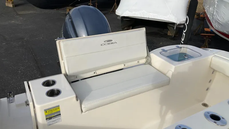 Slide: The Image of 2022 Cobia 220 CC boat interior with seating and cup holders. - 21