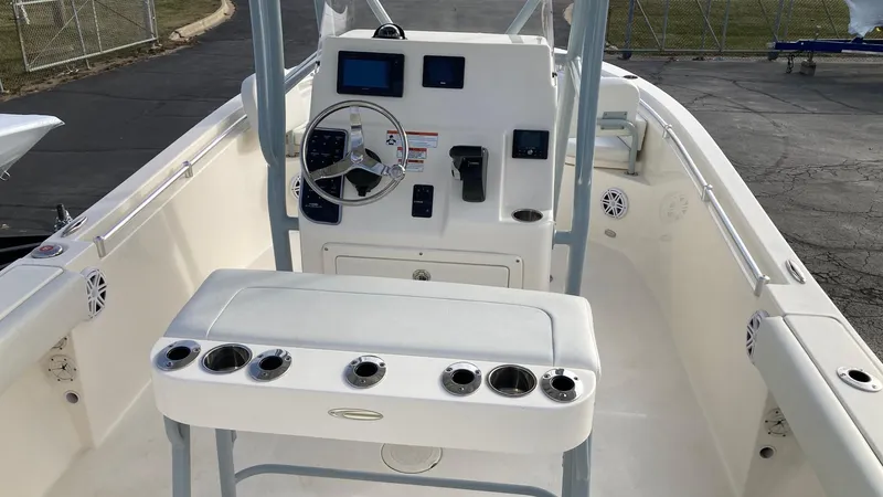 Slide: The Image of 2022 Cobia 220 CC boat interior with steering console and rod holders. - 8