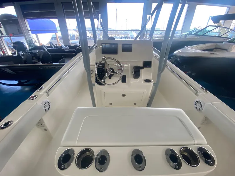 Slide: The Image of 2022 Cobia 220 CC center console boat interior with steering wheel and rod holders. - 9
