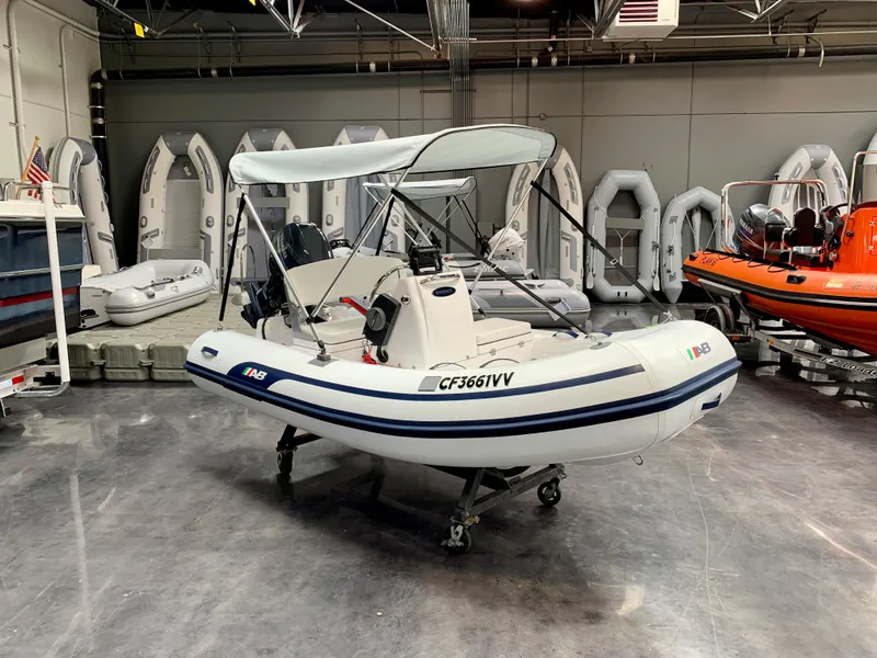 The Image of 2024 AB Inflatables 10 VSX boat in showroom with canopy and console. - 1