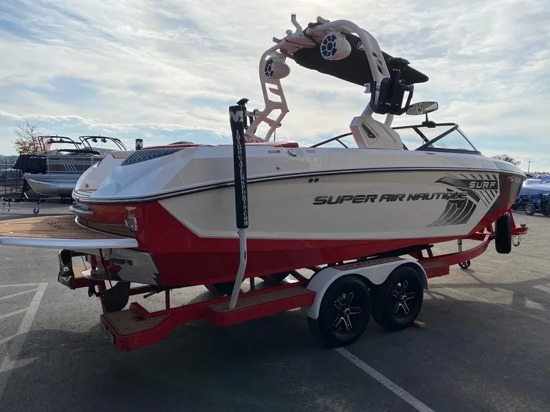 Slide: The Image of 2018 Nautique G23 boat on trailer, red and white design, parked outdoors. - 10