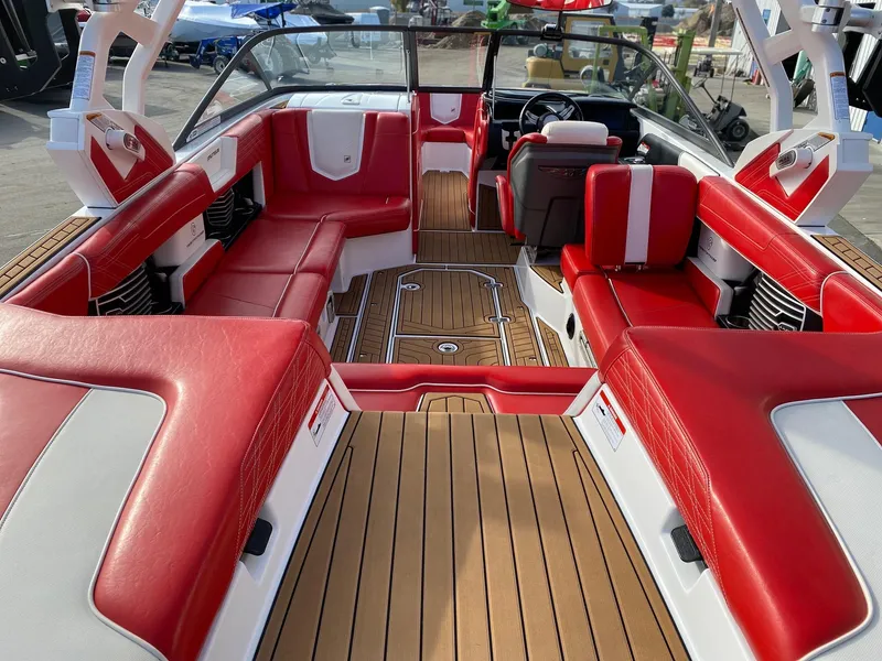 Slide: The Image of 2018 Nautique G23 boat interior with red and white seating, teak flooring. - 16