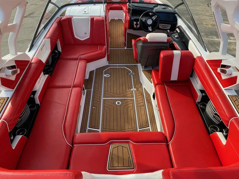 Slide: The Image of 2018 Nautique G23 boat interior with red seating and wood-style flooring. - 17